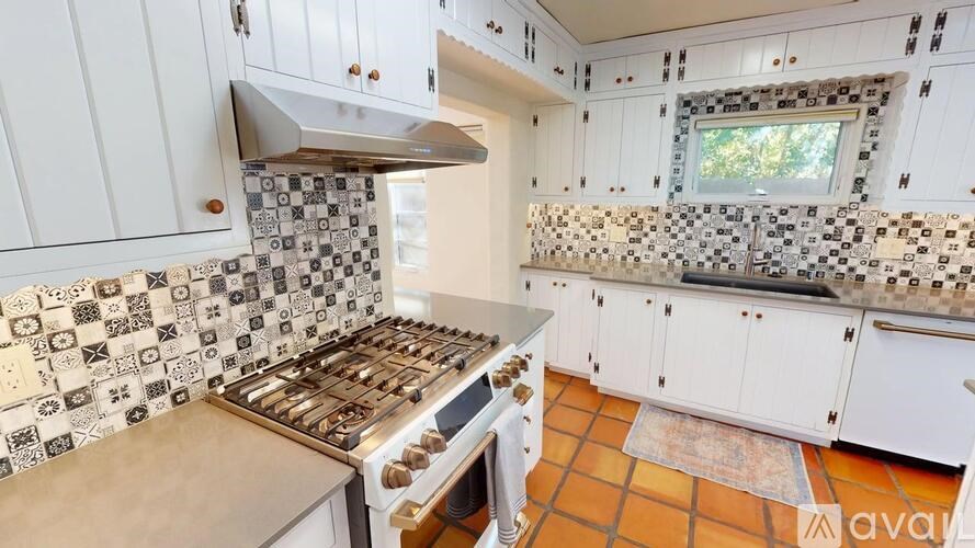 A kitchen with white cabinets and a tile backsplash.