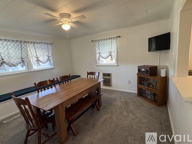 A dining room with a wooden table and chairs.