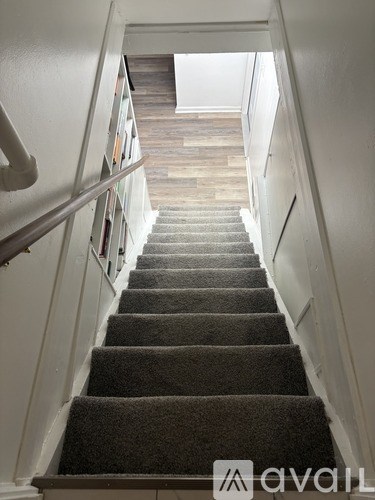 A staircase with a carpeted runner and white walls.
