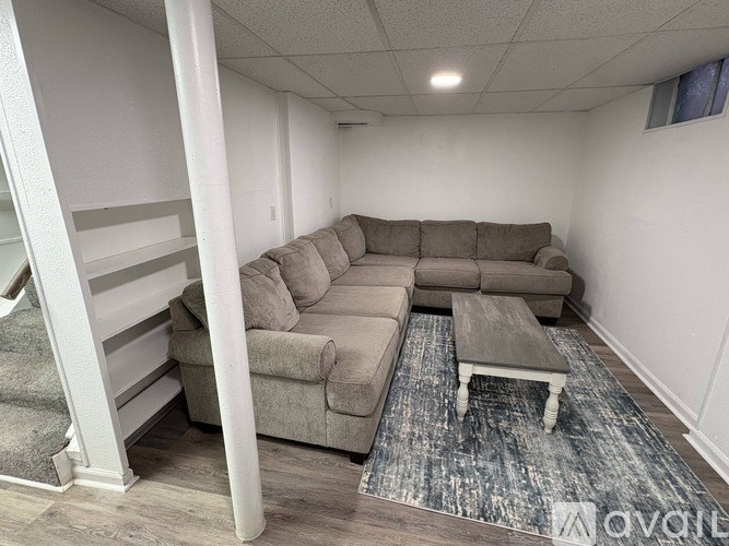 A living room with a grey couch and a coffee table.