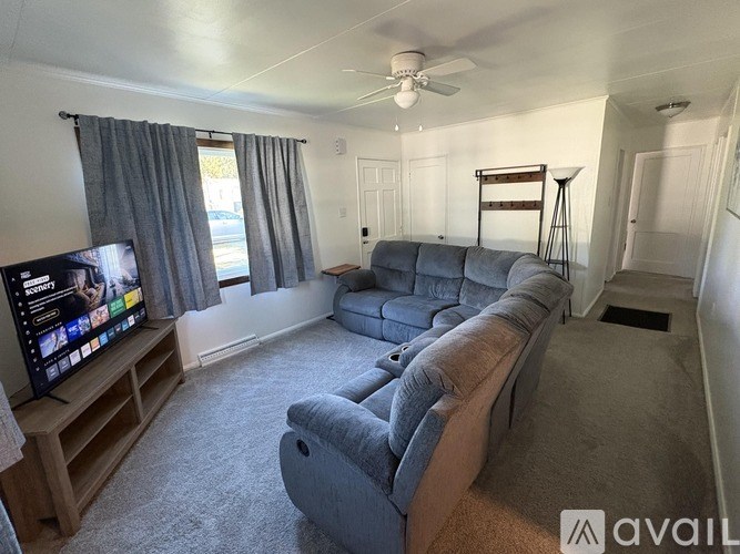 A living room with a grey couch and a flat screen TV.