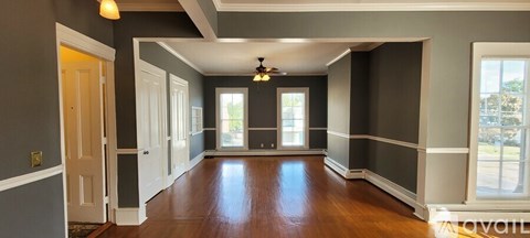 A long hallway with a light on the ceiling and a window on the right wall.
