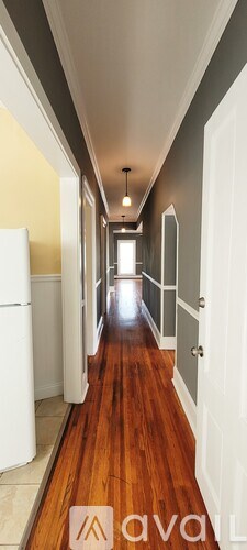 A long hallway with white doors on either side.
