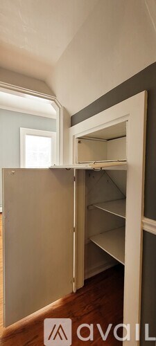A white closet with shelves and a mirror.