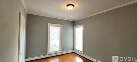 A room with a window and a wooden floor.