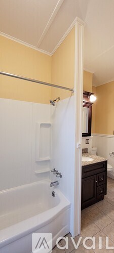 A bathroom with a white tub and a sink with a mirror above it.