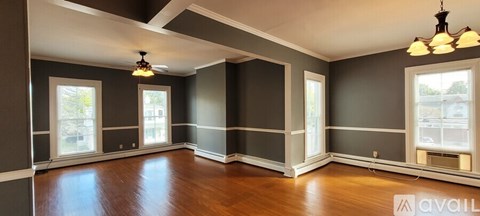 A large empty room with wood floors and a high ceiling.