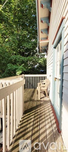 A wooden deck with a white railing and a blue door.