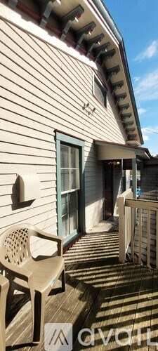 A house with a blue door and a white chair on the porch.