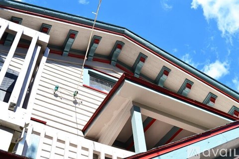A white building with red and green trim under a blue sky.