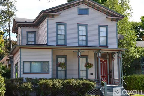 A two-story house with a red door and white trim.