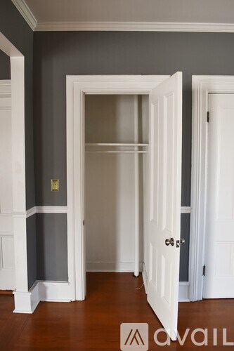 A white door is open to a room with a grey wall.