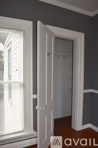 A white door is open to a room with a grey wall.