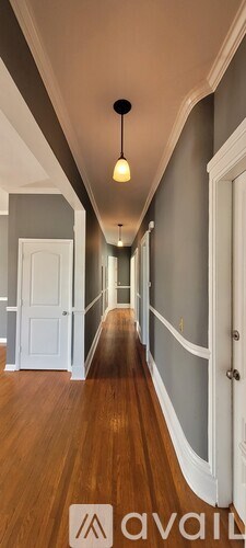 A long hallway with a light hanging from the ceiling.