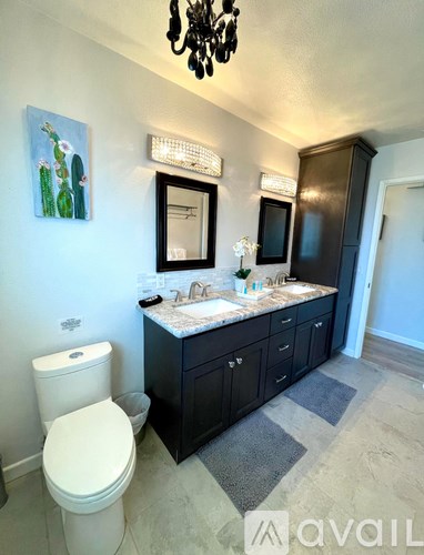 A bathroom with a white toilet and a black cabinet.