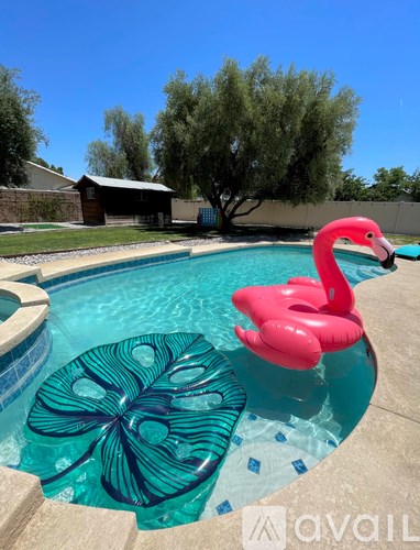 A pink flamingo floats in a pool.