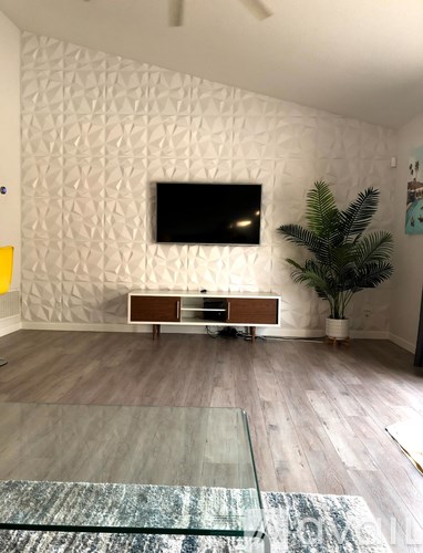 A modern living room with a television and a wooden cabinet.