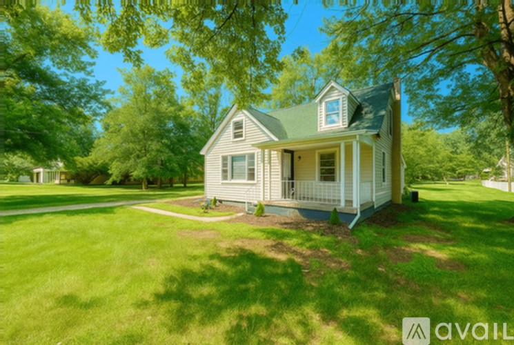 A house with a green lawn and trees in the background.