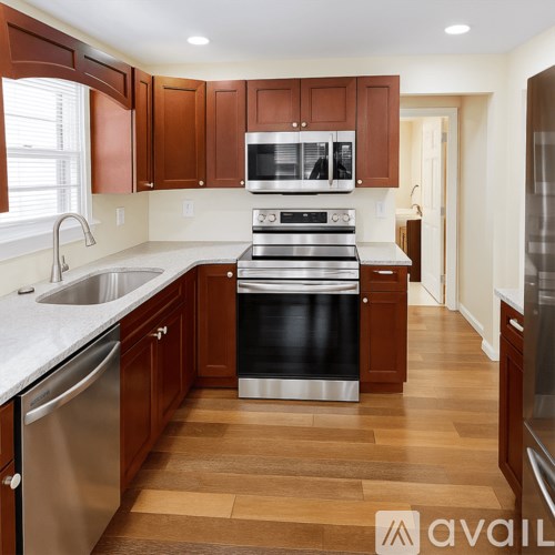 A kitchen with wooden cabinets and a stainless steel oven.
