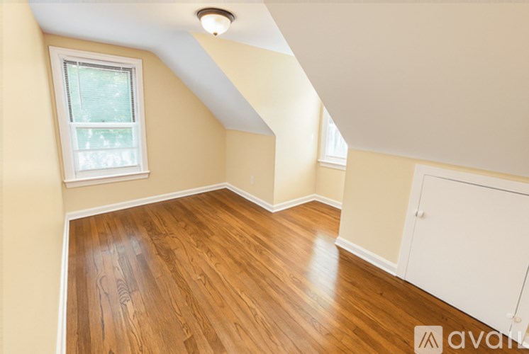 A room with wooden flooring and a window.
