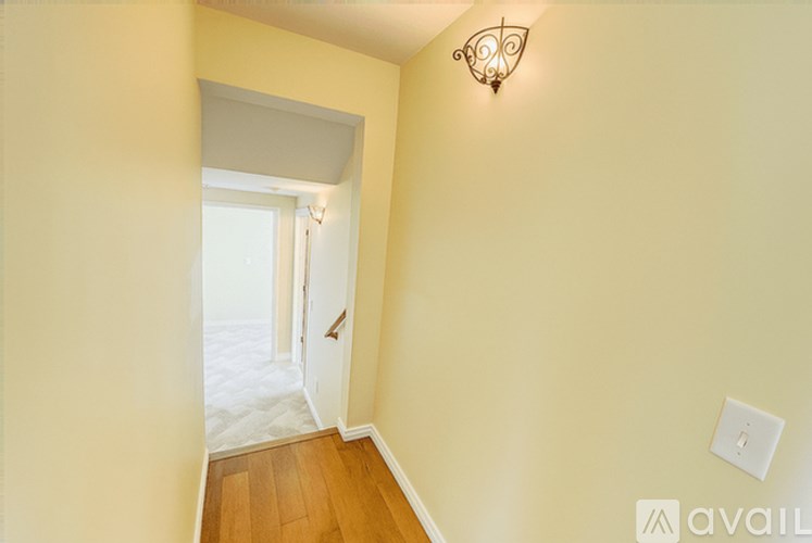 A hallway with a wooden floor and a white door.