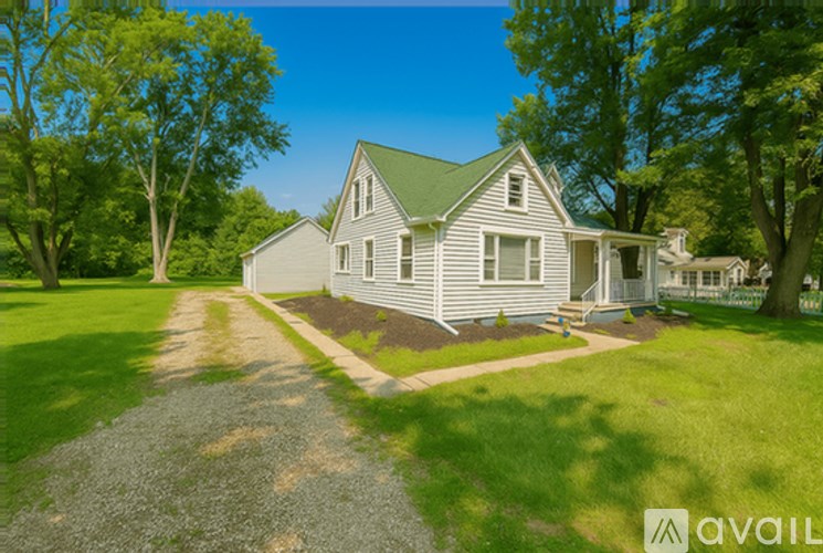 A house with a gravel driveway in front of it.
