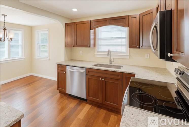 A kitchen with wooden cabinets and a stainless steel dishwasher.