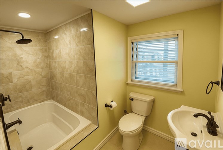 A bathroom with a toilet, sink, and shower.