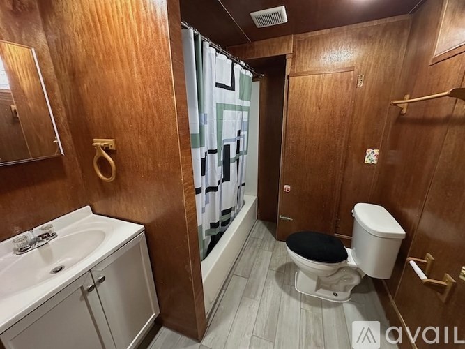 A bathroom with a toilet, sink, and mirror.
