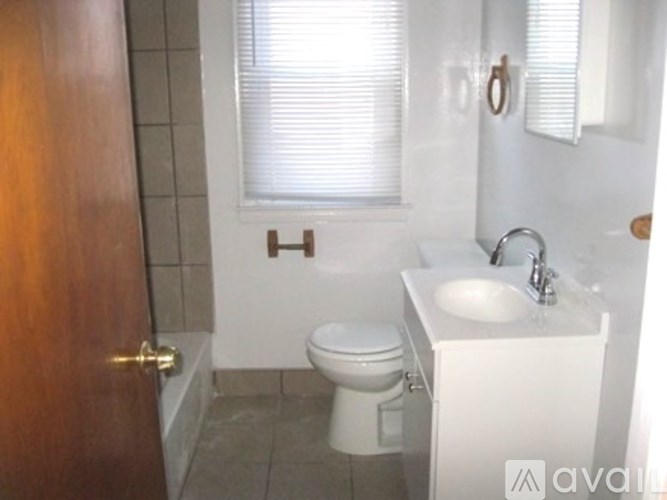 A bathroom with a toilet, sink and a door.