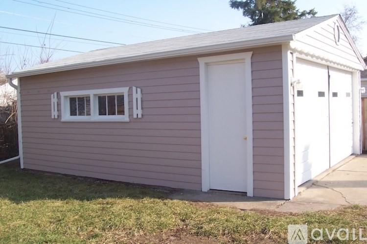 A small building with a white door and windows with shutters.