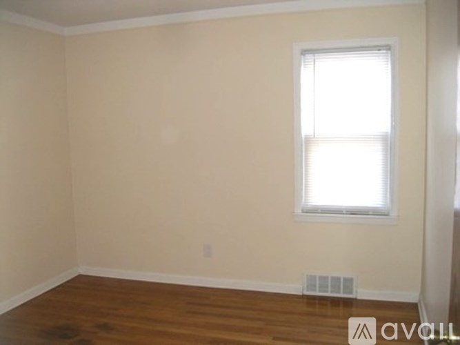 A room with a window and wooden floors.