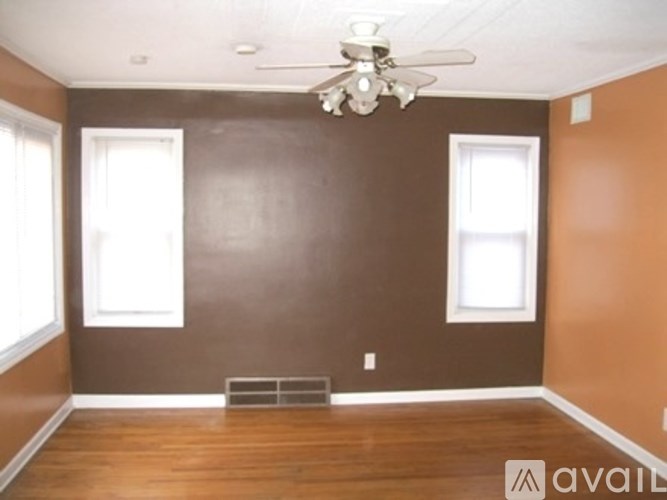 A room with brown walls and a ceiling fan.