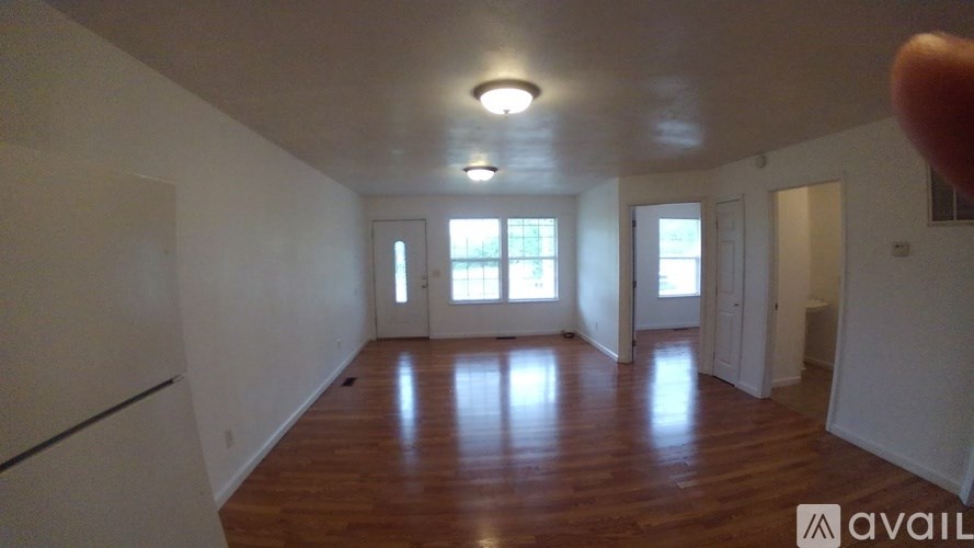 A room with wooden floors and white walls is available for rent.