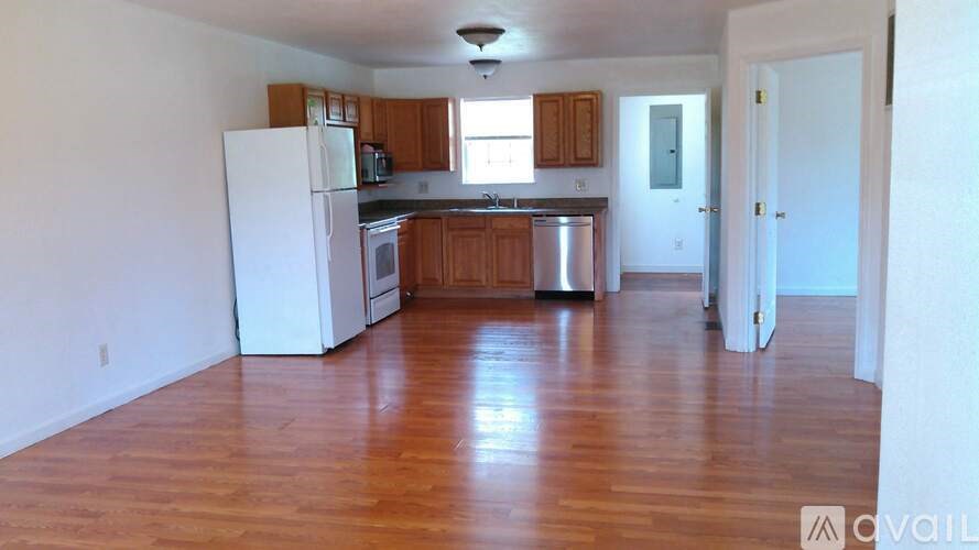A kitchen with wooden floors and white appliances.