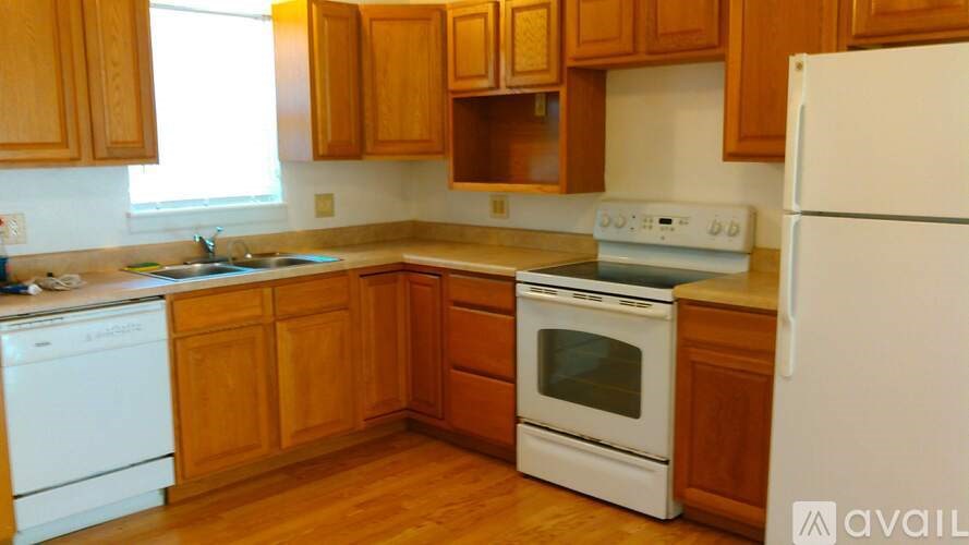 A kitchen with wooden cabinets and white appliances.