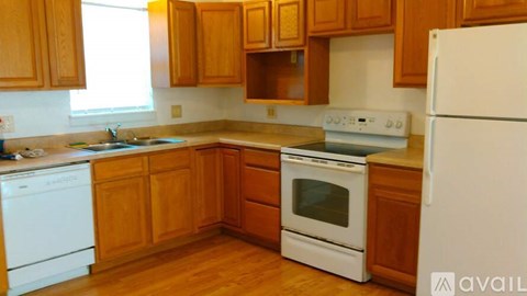 A kitchen with wooden cabinets and white appliances.