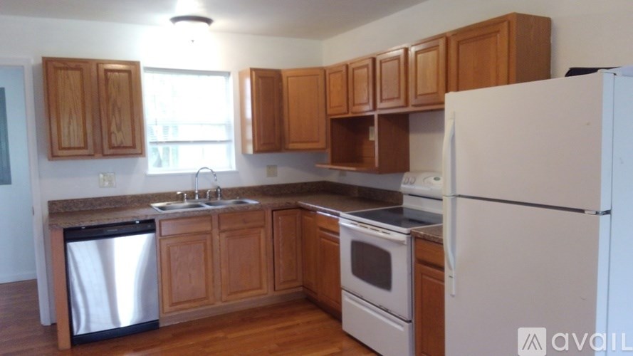 A kitchen with wooden cabinets and a white refrigerator.