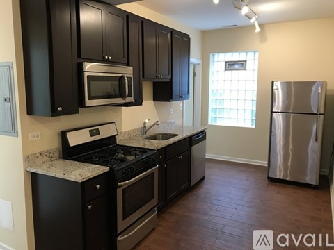 A kitchen with black cabinets and stainless steel appliances.