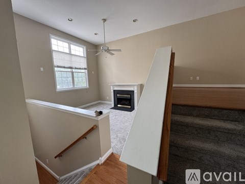 A living room with a fireplace and a ceiling fan.