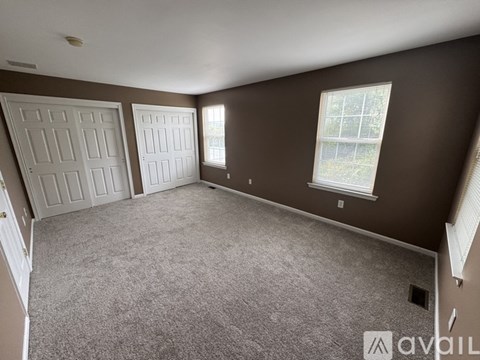 A room with two doors and two windows.