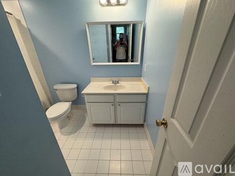 A bathroom with blue walls and white fixtures.