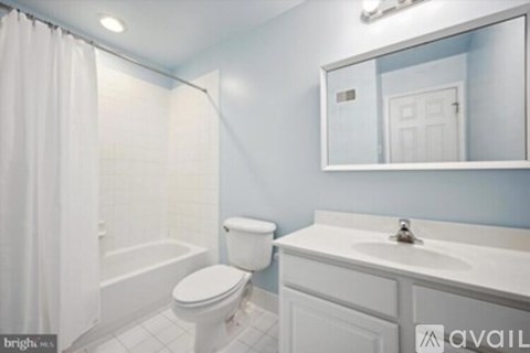 A white toilet sits next to a sink in a bathroom.