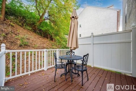 A patio with a table and chairs and an umbrella.