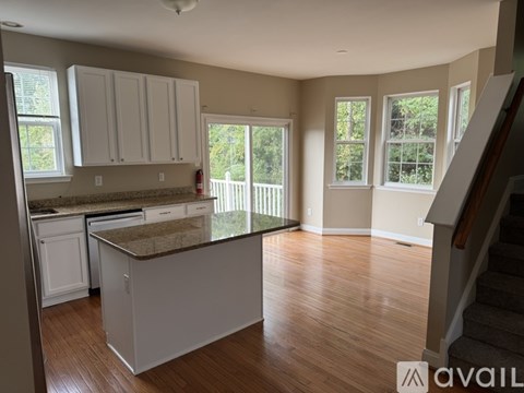 A kitchen with white cabinets and a granite countertop.