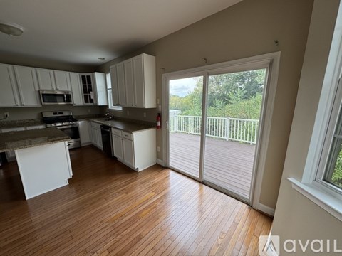 A kitchen with white cabinets and a wooden floor.