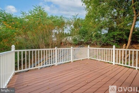 A deck with white railings and a wooden floor.
