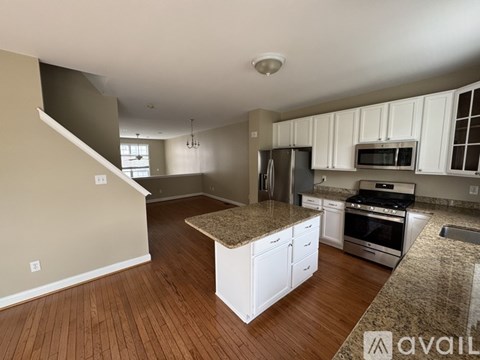 A kitchen with white cabinets and a granite countertop.