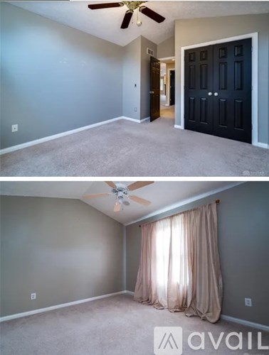 A room with a ceiling fan and a door.