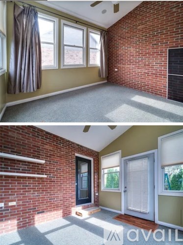 A room with a brick wall and a window with a curtain.